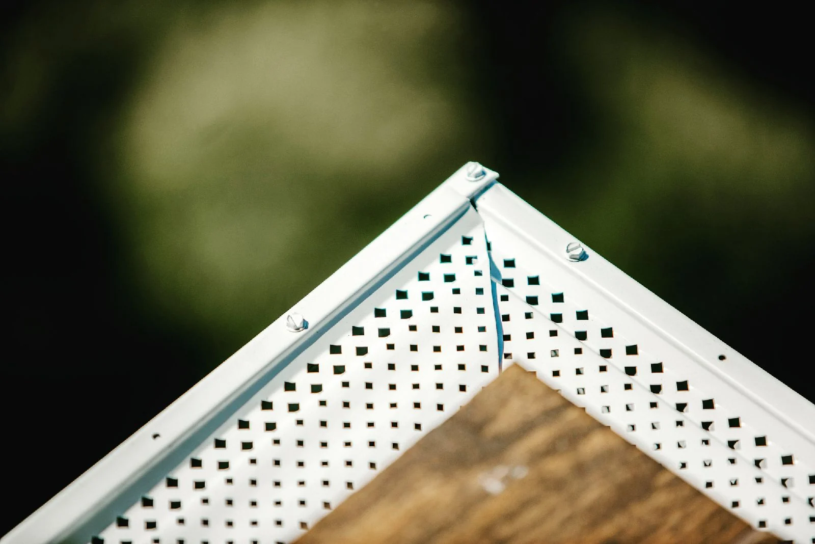 Perforated leaf guard fitted to a rain gutter